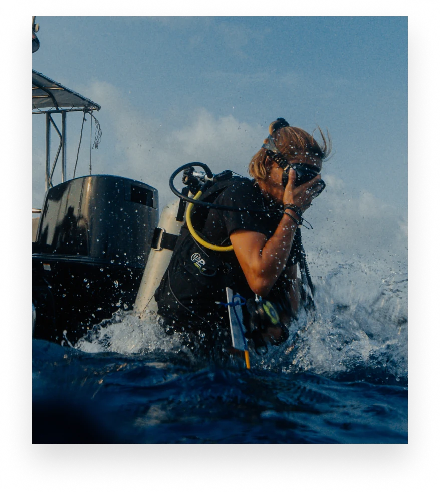 A Gardener in scuba gear stepping off the boat into the water