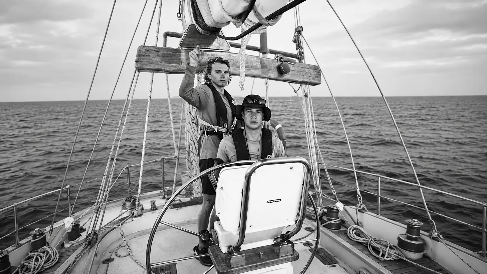 Charlie and Aidan at the helm of a sailing boat