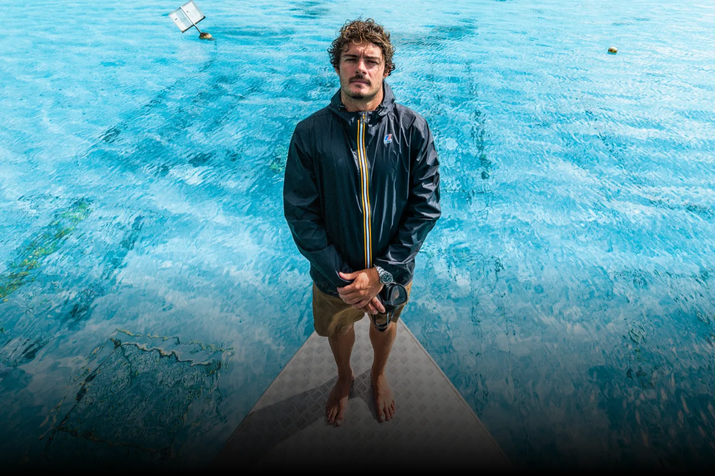 A Gardener in a K-Way jacket on the bow over clear water